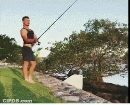 Man Holding Fishing Rod On Stone Wall GIF