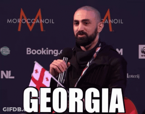 Man Holding Flag And Microphone Saying Georgia GIF