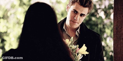 Man Holding Flowers Looking At Woman GIF
