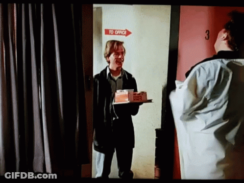 Man Holding Food Tray In Front Of Red Office Door GIF