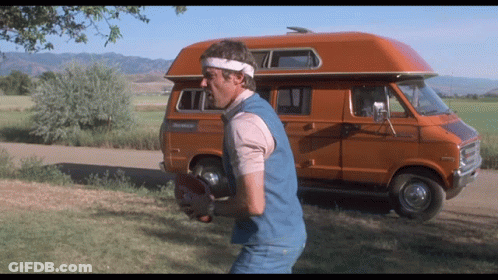 Man Holding Football Beside Orange Van RV GIF
