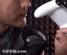 Man Holding Game Controller Talking Into Microphone GIF