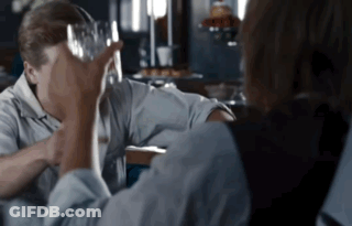 Man Holding Glass Over Head While Another Looks On GIF