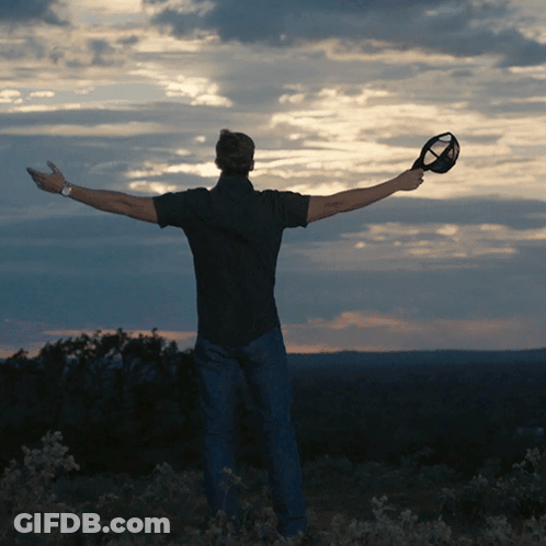 Man Holding Glass With Arms Outstretched GIF