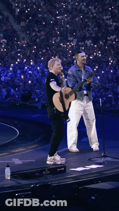 Man Holding Guitar And Singer At Microphones GIF