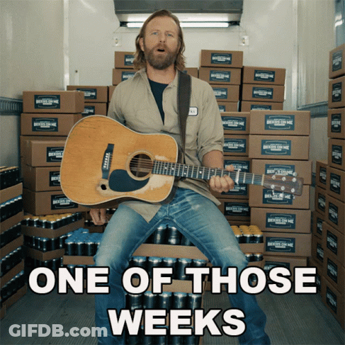 Man Holding Guitar In Front Of Boxes GIF