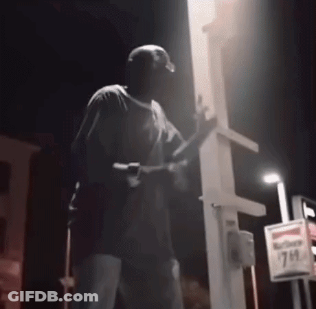 Man Holding Gun At 7 Eleven Sign Night GIF