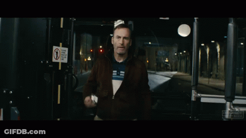 Man Holding Gun By Sign Saying Please Keep Back Of Yellow Line GIF