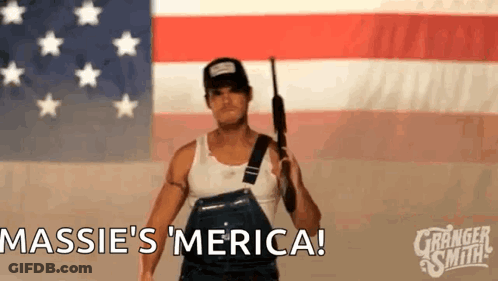 Man Holding Gun In Front Of American Flag Saying Massie 'S Merica GIF