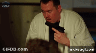 Man Holding Gun In Front Of Comedy Cult Screen GIF