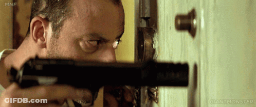Man Holding Gun In Front Of Door With Giantmonster GIF
