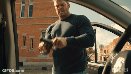 Man Holding Gun In Front Of Reacher Logo GIF