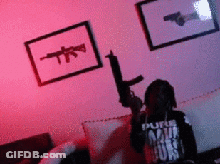 Man Holding Gun In Living Room With Gun Picture On Wall GIF