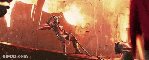 Man Holding Gun On Bridge In Front Of Fire GIF