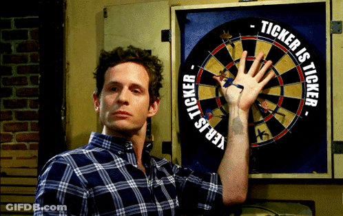 Man Holding Hand In Front Of Dart Board Saying Ticker Is Ticker GIF