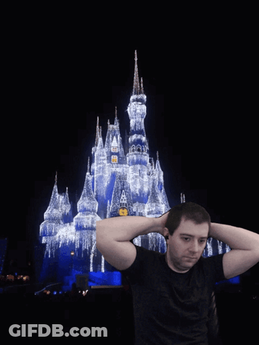 Man Holding Hands Behind Head In Front Of Disney Castle GIF