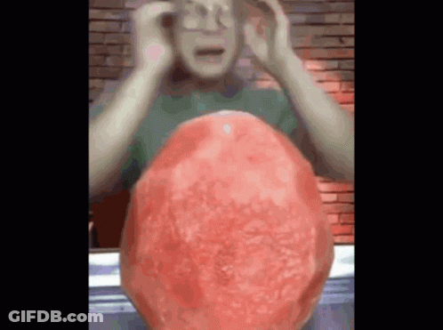 Man Holding Head In Front Of Giant Watermelon GIF
