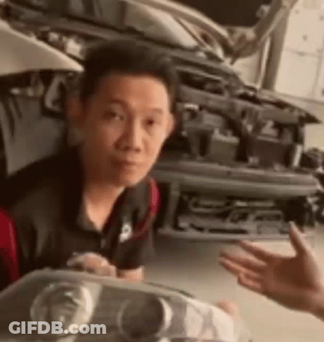 Man Holding Headlight In Front Of Car GIF