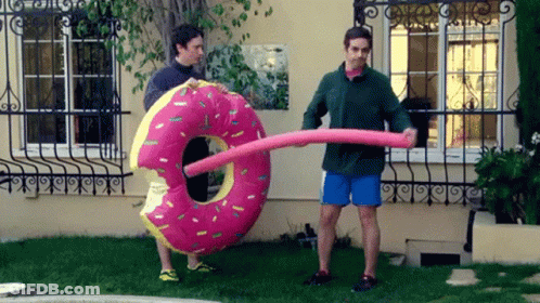 Man Holding Large Pink Donut Float GIF