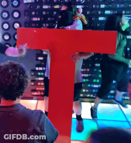 Man Holding Large Red Letter T GIF