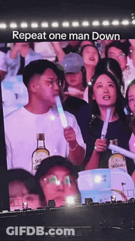 Man Holding Light Stick In Front Of Crowd Repeat One Man Down GIF