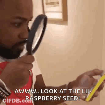 Man Holding Magnifying Glass Looking At Phone GIF