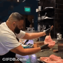 Man Holding Meat Near Exit Sign GIF