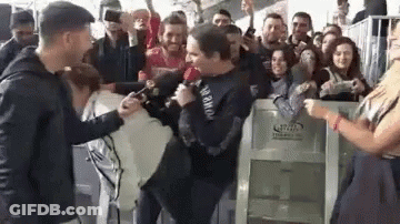 Man Holding Microphone In Crowd GIF