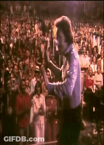 Man Holding Microphone In Front Of Crowd GIF