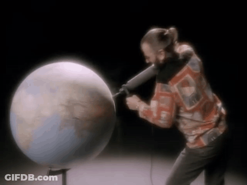 Man Holding Microphone In Front Of Globe GIF