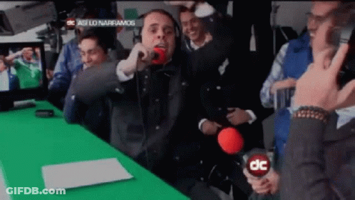 Man Holding Microphone In Front Of Green Screen Saying DC GIF