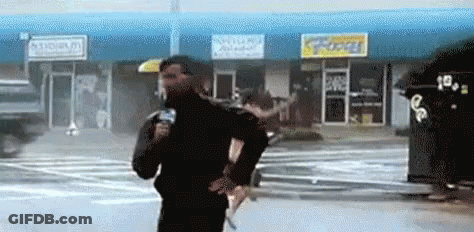 Man Holding Microphone In Front Of Store GIF