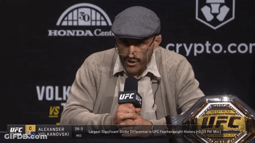 Man Holding Microphone In Front Of UFC Championship Belt GIF