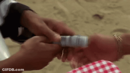 Man Holding Money On Woman's Wrist At Beach GIF