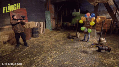 Man Holding Paintball Gun In Front Of Flinch Sign GIF