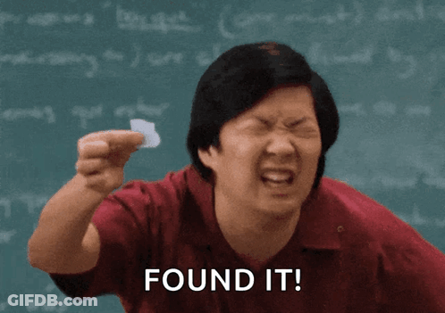 Man Holding Paper In Front Of Chalkboard Saying Found It GIF
