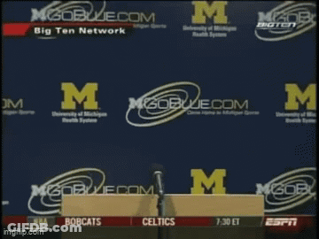 Man Holding Paper In Front Of M Logo GIF