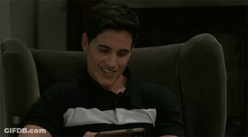 Man Holding Phone With Two Men Kissing On Screen GIF