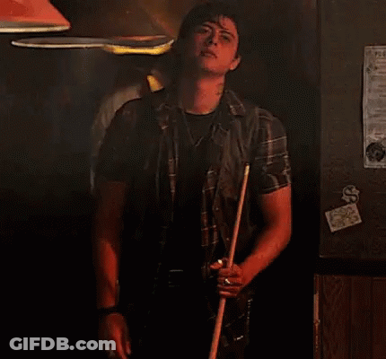 Man Holding Pool Cue In Dark Room GIF