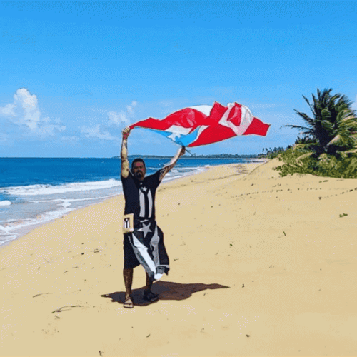 Man Holding Puerto Rico Flag At The Beach GIF