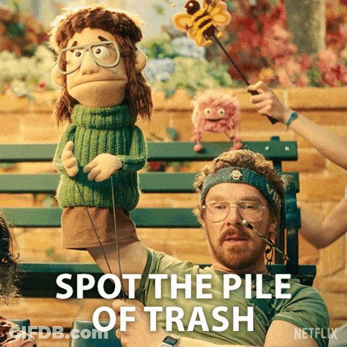 Man Holding Puppet Saying Spot The Pile Of Trash GIF