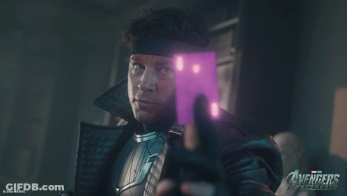 Man Holding Purple Object In Front Of Avengers Poster GIF