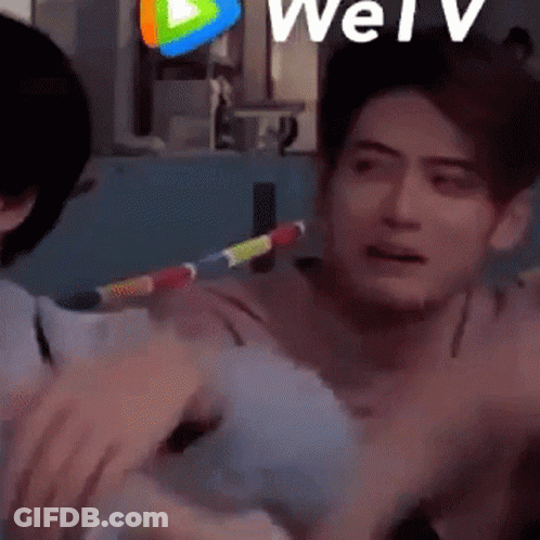Man Holding Rainbow Hula Hoop While Another Man Watches GIF