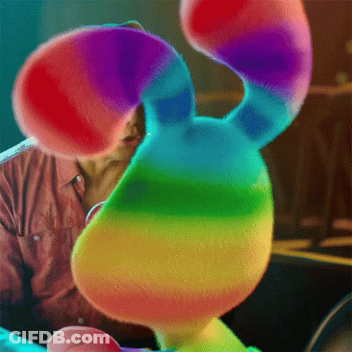 Man Holding Rainbow Stuffed Animal GIF