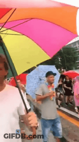 Man Holding Rainbow Umbrella Walking GIF