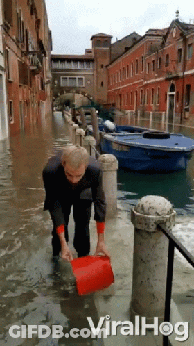 Man Holding Red Bucket In Flood GIF