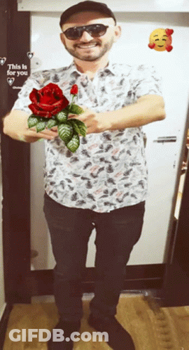 Man Holding Red Rose In Front Of Door Saying This Is For You GIF