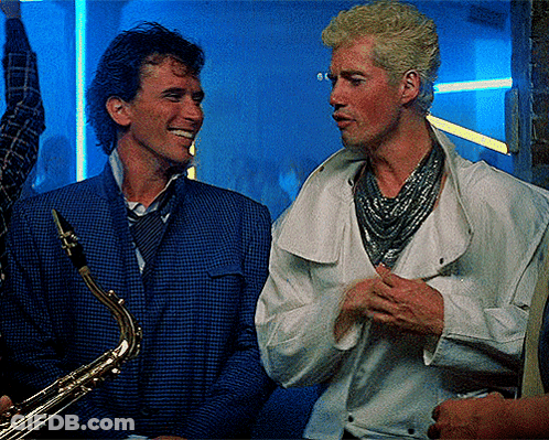 Man Holding Saxophone Talking To Man GIF