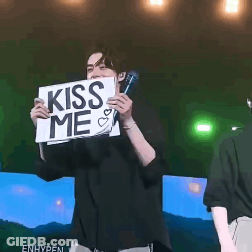 Man Holding Sign Saying Kiss Me With Microphone GIF