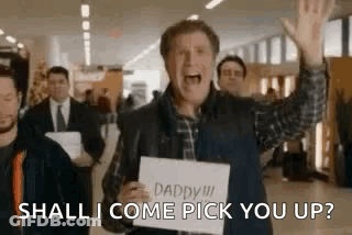 Man Holding Sign Saying Shall I Come Pick You Up GIF